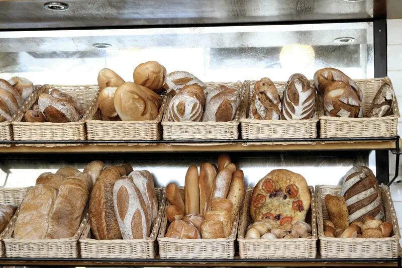 Des pains rangés dans des panières en osier sur des étagères
